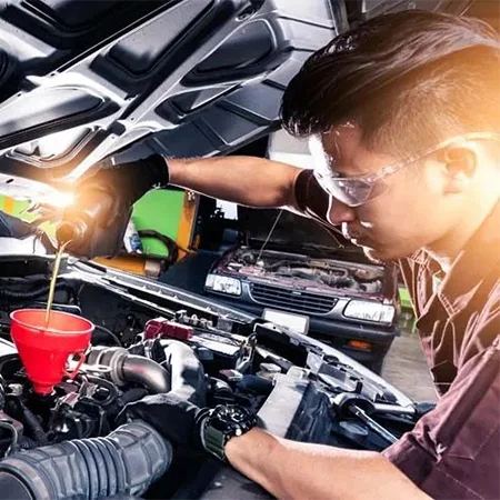 Mecánico inspeccionando el motor de un vehículo durante una revisión por kilometraje